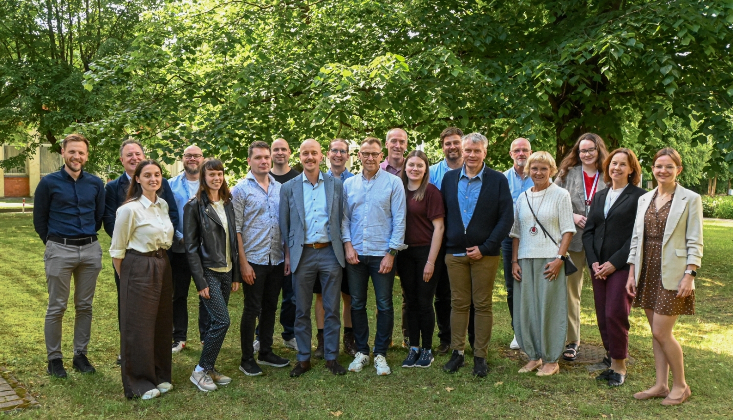 Ziemeļvalstu un Baltijas valstu pārstāvji kopbildē. Fonā zaļas koka lapas