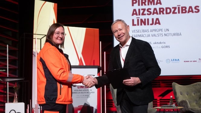 NMPD direktore un Veselības aprūpes darba devēju asociācijas valdes priekšēdētājs sarokojas pēc sadarbības līguma parakstīšanas