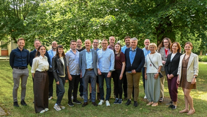 Ziemeļvalstu un Baltijas valstu pārstāvji kopbildē. Fonā zaļas koka lapas