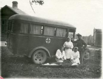 Kārsavas slimnīcas ēka, ātrās palīdzības mašīna un darbinieki ap 1947.gadu. Foto no P.Stradiņa Medicīnas vēstures muzeja krājuma.