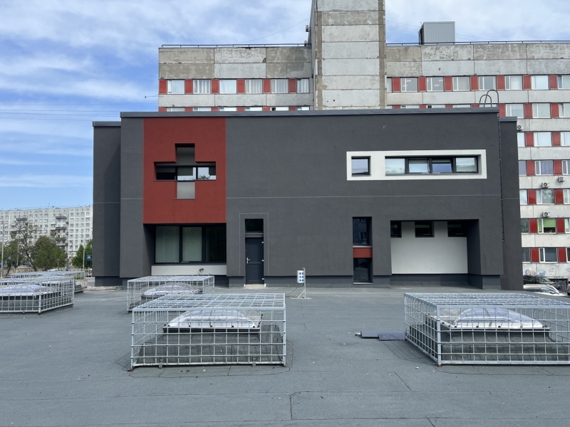 Atjaunota NMPD brigāžu atbalsta centra ēkas fasāde - ēka pelēkā krāsā ar sarkanu akcentu