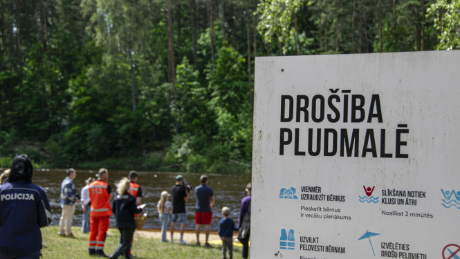 Norāde - drošība pludmalē un fonā redzami cilvēki