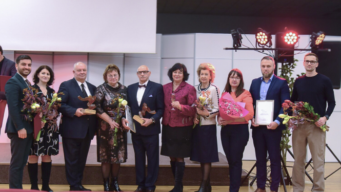 NM asociācijas apbalvojums, apbalvojuma saņēmēji ar ziediem stāv uz skatuves