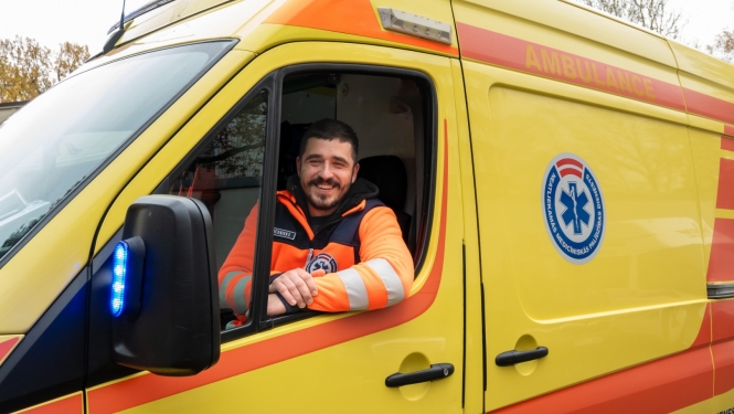 A. Mucenieks, operatīvā auto vadītājs sēž operatīvajā auto un skatās ārā pa logu