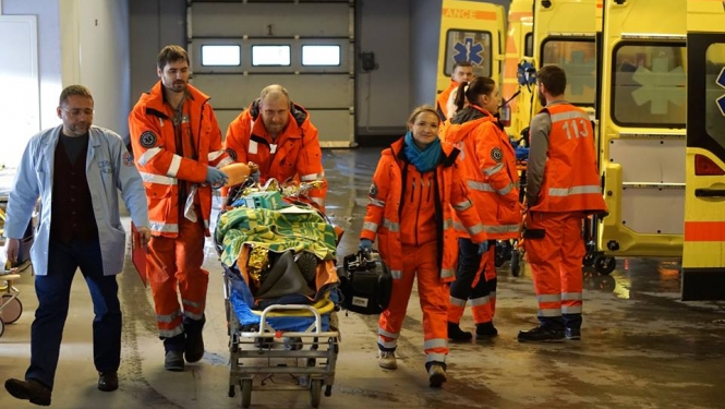 Mediķi situāciju mācībās nogādā slimnīcā pacientu, fonā vairākas brigādes un operatīvie auto