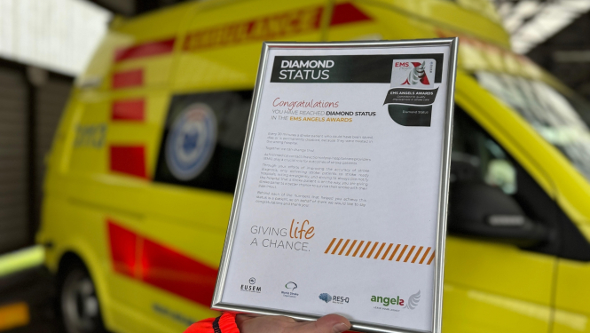 Eņģeļu iniciatīvas dimanta statusa apbalvojums piešķirts NMPD. Apbalvojumam fonā redzams NMPD operatīvais auto