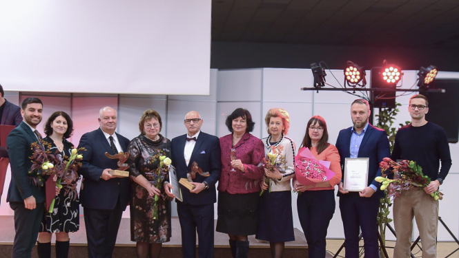 NM asociācijas apbalvojums, apbalvojuma saņēmēji ar ziediem stāv uz skatuves