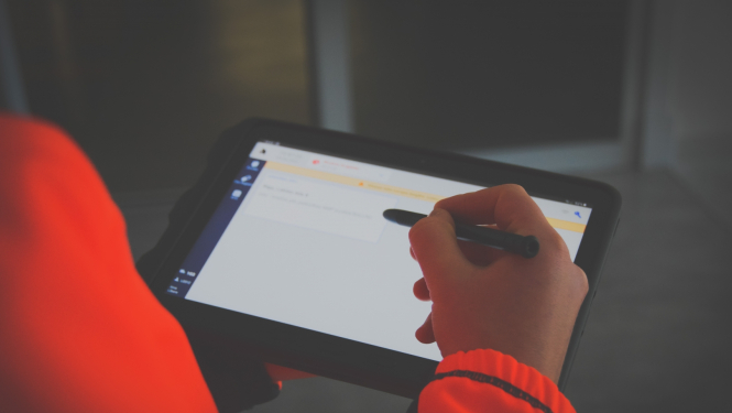 NMPD darbinieks formā tur rokā jauno planšetdatoru