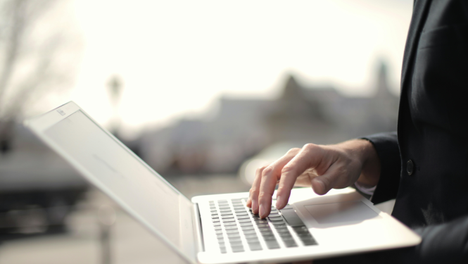 cilvēks rokās tur klējpdatoru