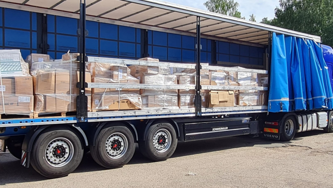 Kravas mašīna, kura ir sapakotas kastes