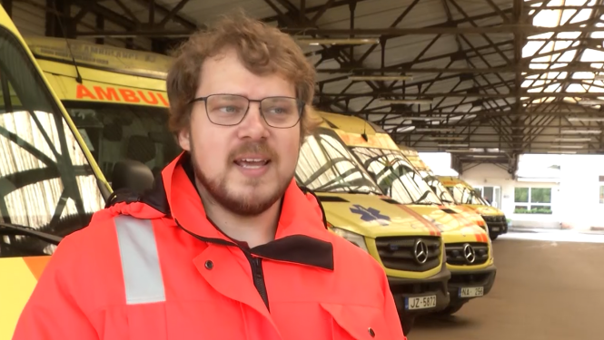 Mediķis tiek intervēts, fonā operatīvie auto