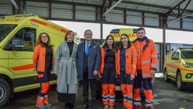 Veselības ministrs, dienesta direktore un NMPD mediķi stāv pie operatīvajiem auto