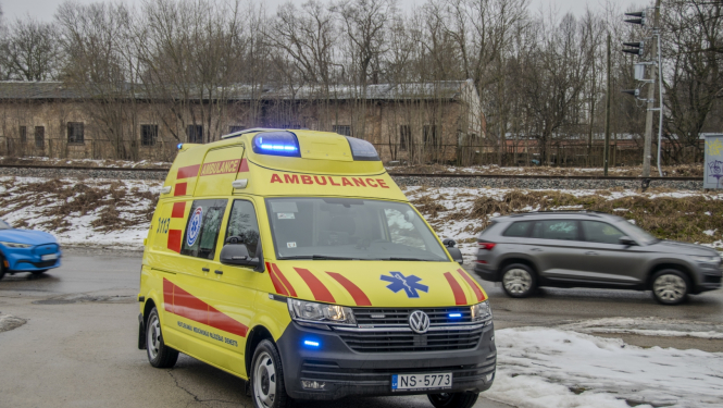 NMPD operatīvais auto, fonā pa ceļu garām brauc 2 mašīnas