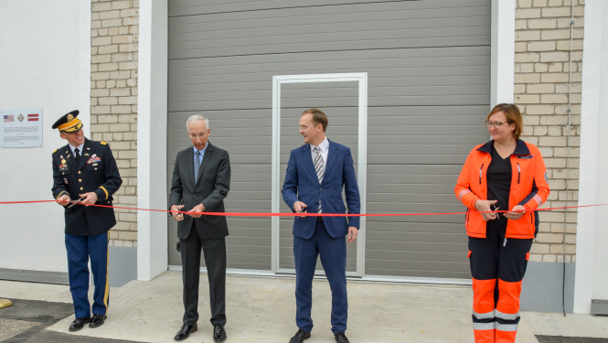 iestāžu pārstāvji griež lentīti, atklājot renovēto ēku