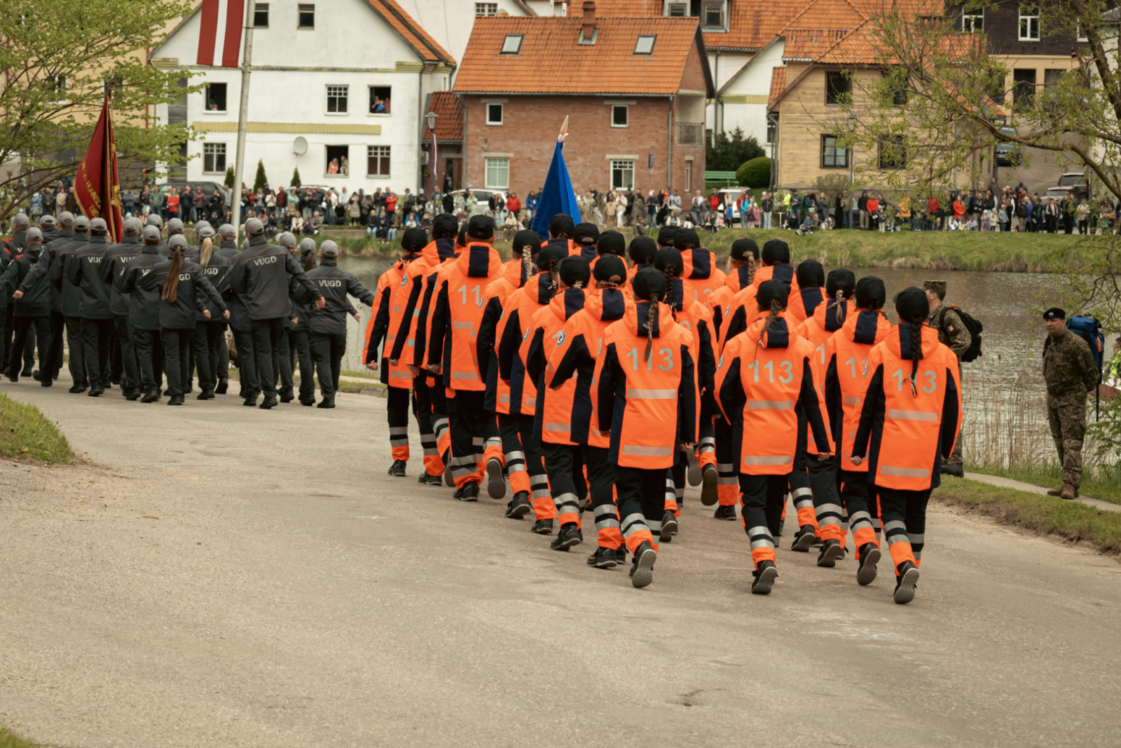 NMPD darbinieki oranžajās formās soļo ierindā