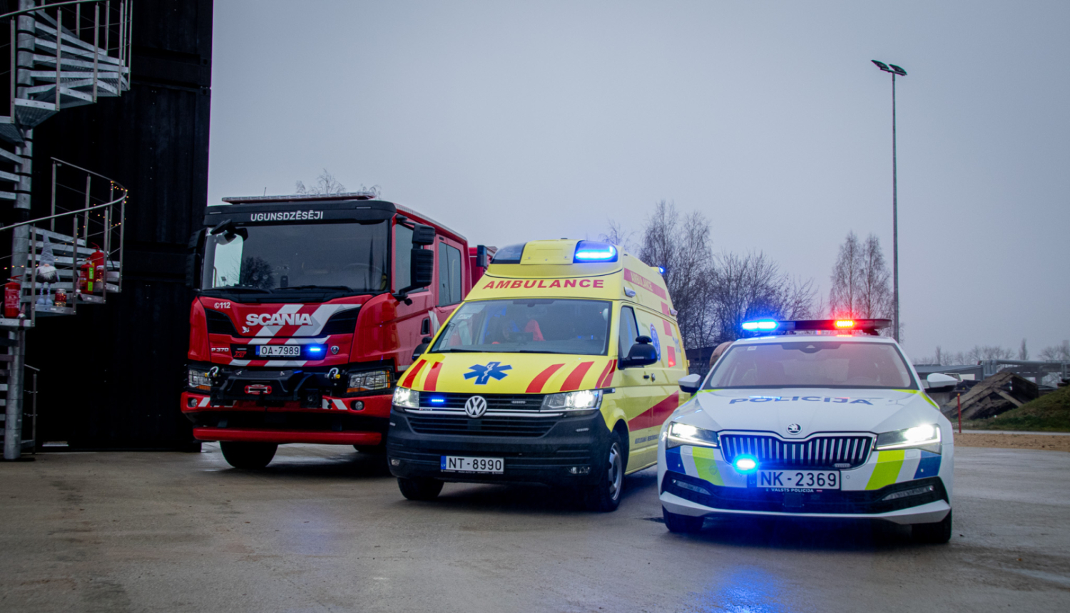 Valsts policijas, VUGD un NMPD automāšīnas stāv blakus ar ieslēgtām bākugunīm