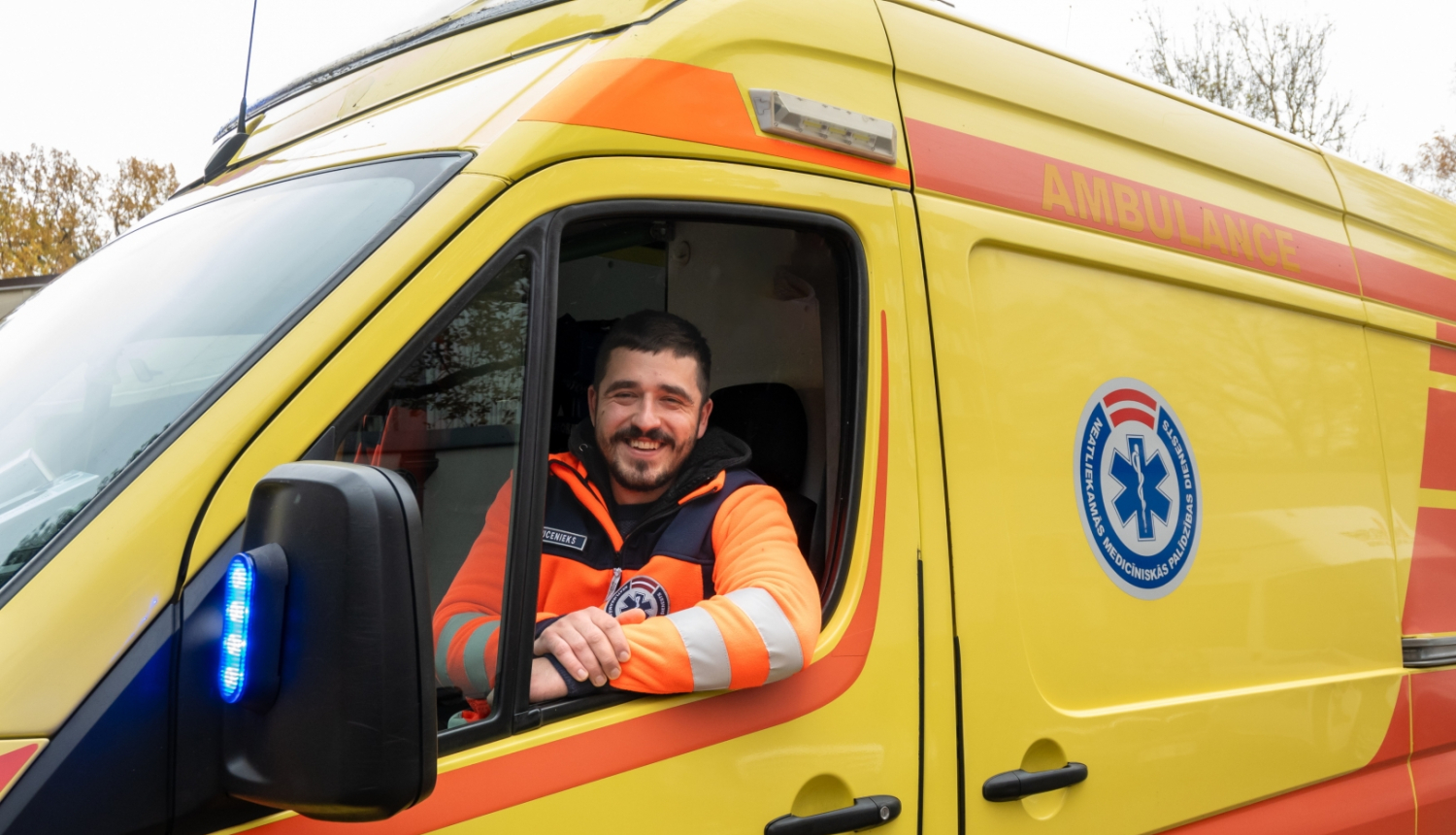 A. Mucenieks, operatīvā auto vadītājs sēž operatīvajā auto un skatās ārā pa logu