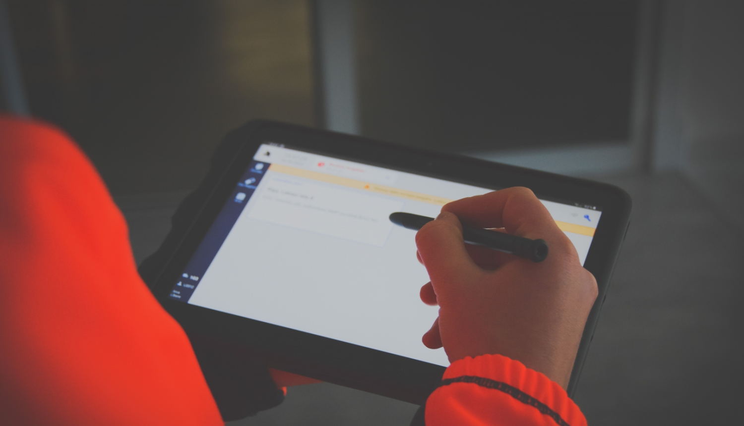 NMPD darbinieks formā tur rokā jauno planšetdatoru