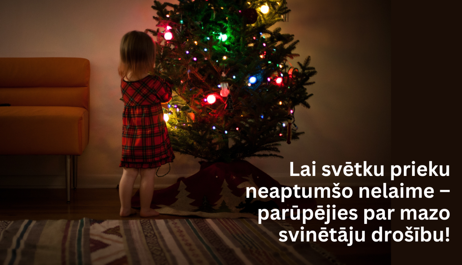 Bērns pie eglītes un teksts fonā - lai svētku prieku neaptumšo nelaime - parūpējies par mazo svinētāju drošību