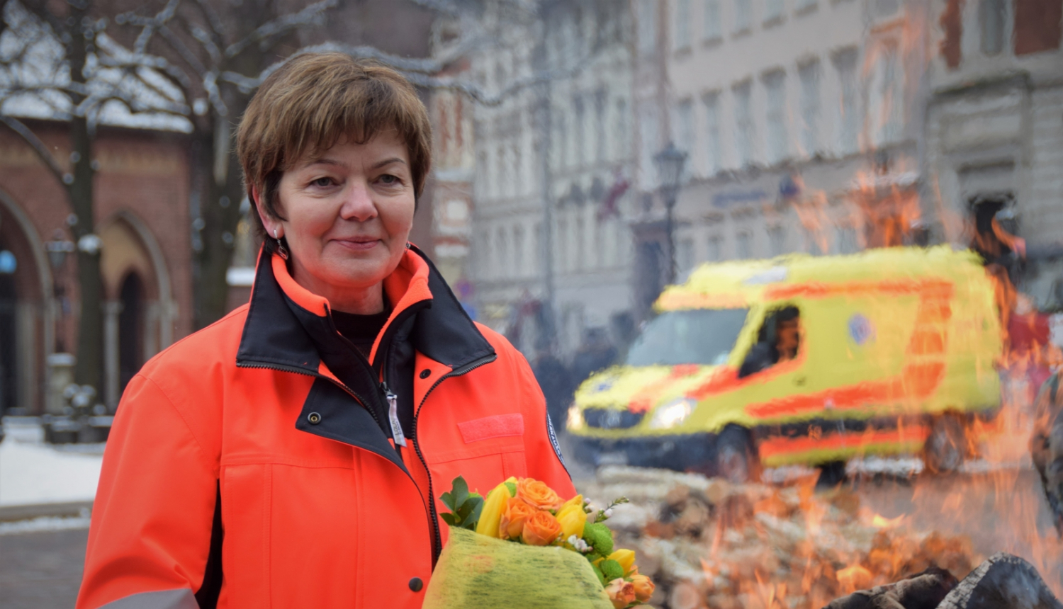 Dr. Dzintra Jakubaņeca stāv NMPD formā un fonā redzams operatīvais auto un ugunskurs