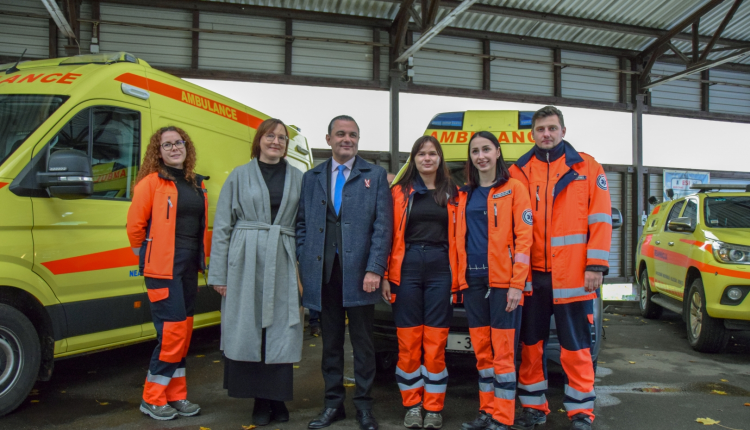 Veselības ministrs, dienesta direktore un NMPD mediķi stāv pie operatīvajiem auto