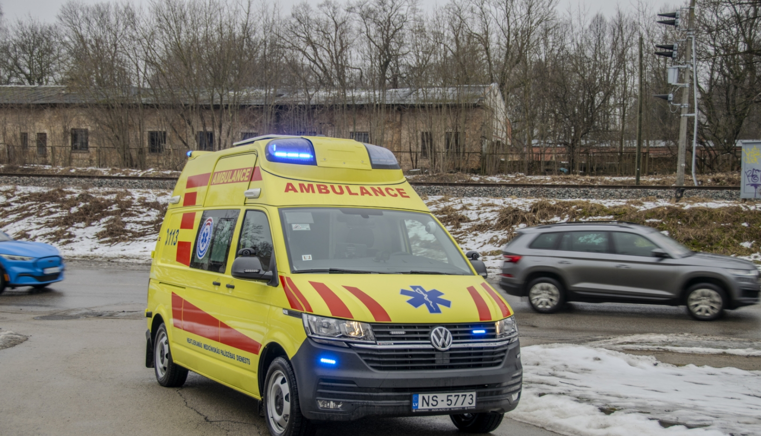 NMPD operatīvais auto, fonā pa ceļu garām brauc 2 mašīnas