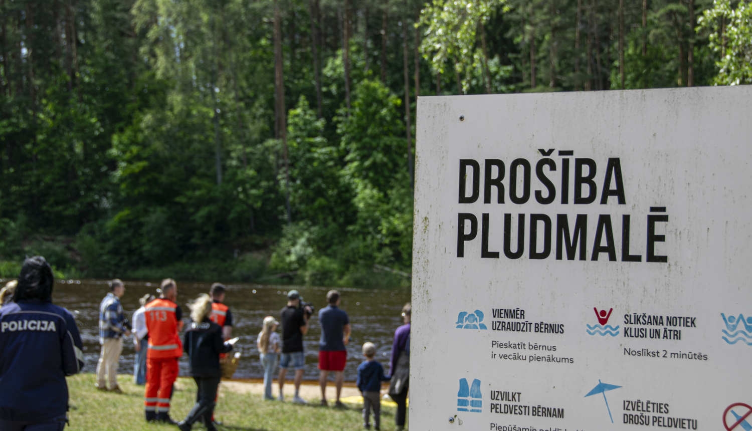 Norāde - drošība pludmalē un fonā redzami cilvēki