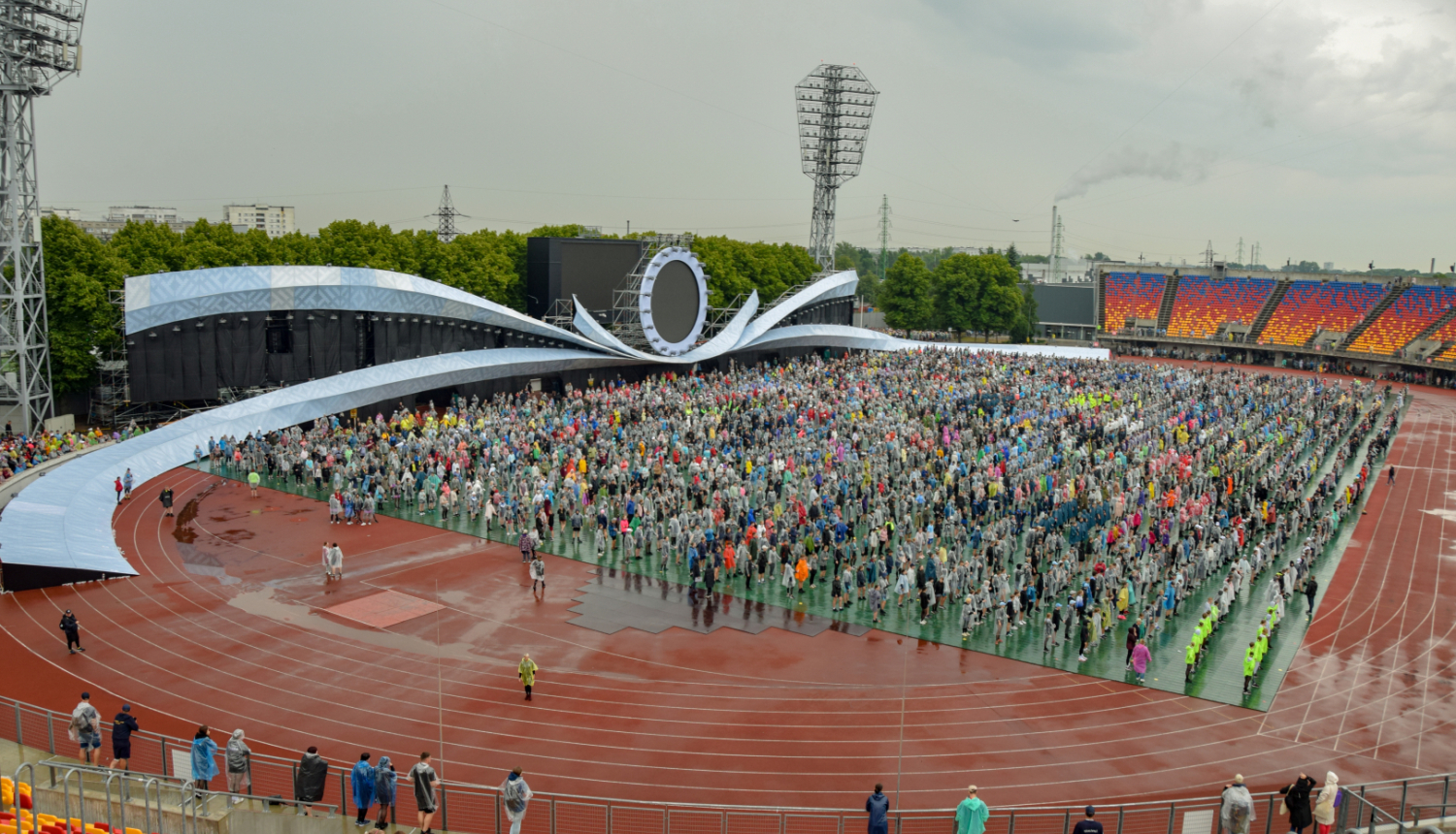 Daugavas stadionā pulcējas Dziesmu un deju svētku dalībnieki, apkārt nedaudz nomākušās debesis