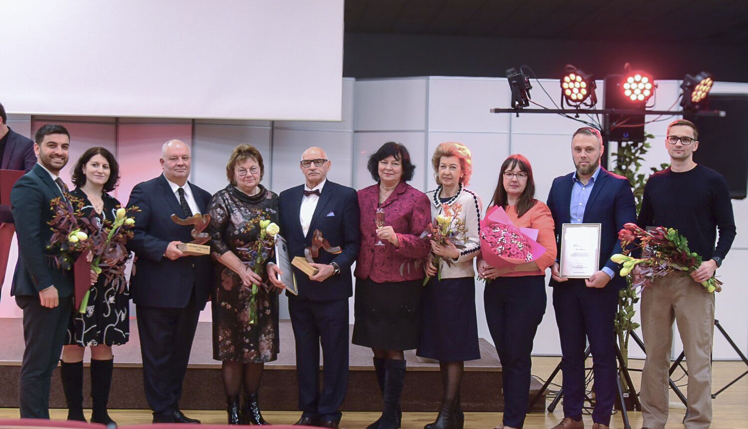 NM asociācijas apbalvojums, apbalvojuma saņēmēji ar ziediem stāv uz skatuves