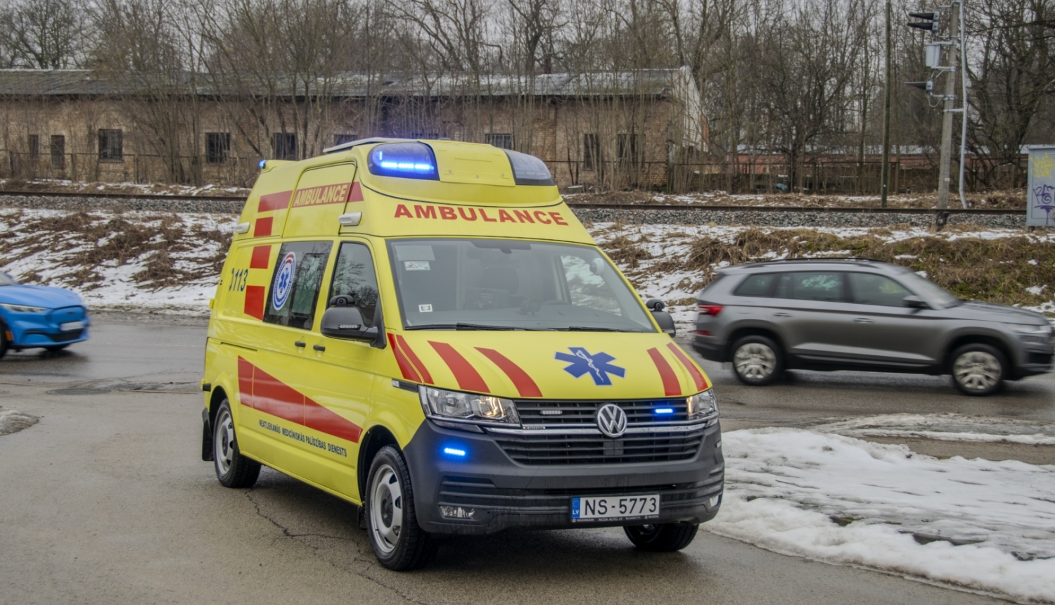 NMPD operatīvais auto, fonā pa ceļu garām brauc 2 mašīnas