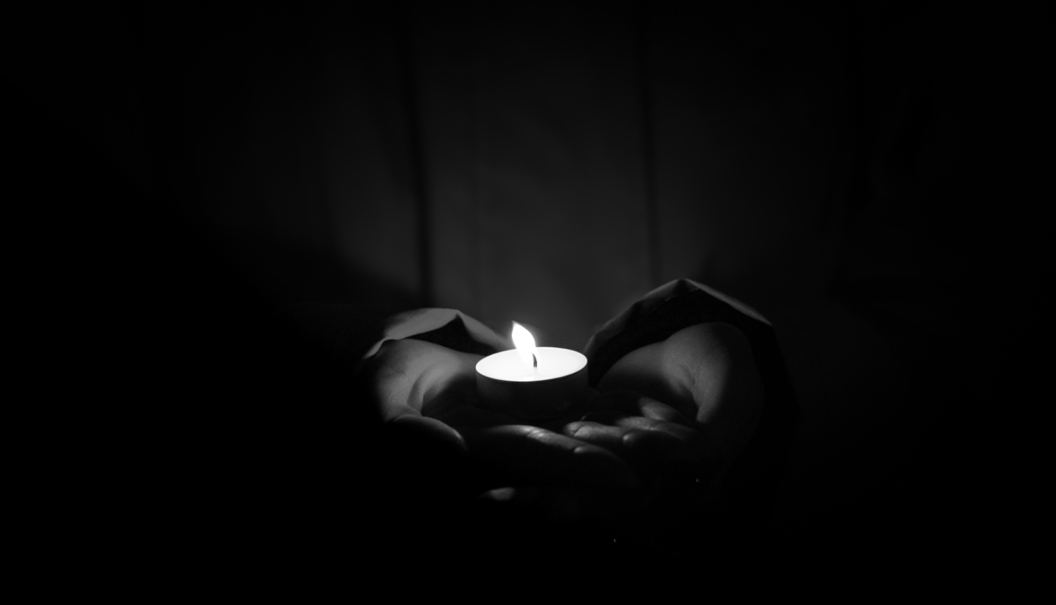 rokās tiek turēta aizdegta svecīte